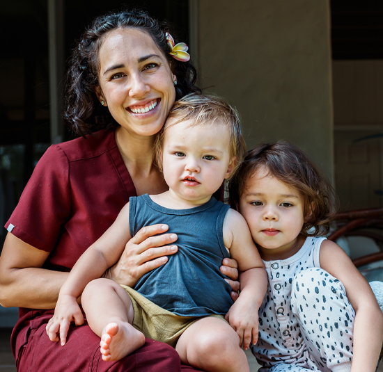 Image of Mother holding children happy